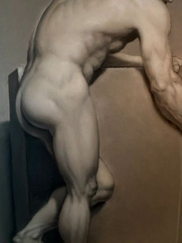 A muscular nude male figure lying on a surface, showcasing detailed anatomy.