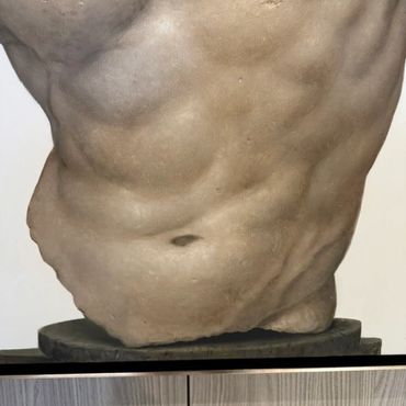 Close-up of a muscular male torso sculpture.