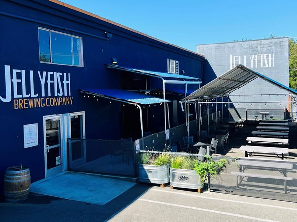  an exterior view of the restaurant with tables and chairs set up outside.