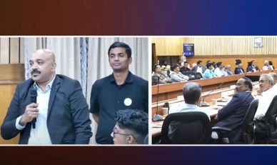 A formal meeting with speakers and audience in a conference room.