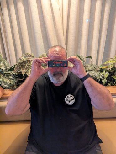 Man holding a vintage Quizard game device up to his eyes.