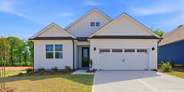 Modern single-story white house with a double garage and landscaped lawn.