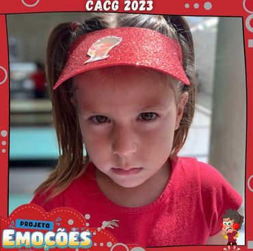 Young girl in red visor and shirt with serious expression.