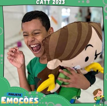 Boy joyfully hugs a large doll, expressing happiness.
