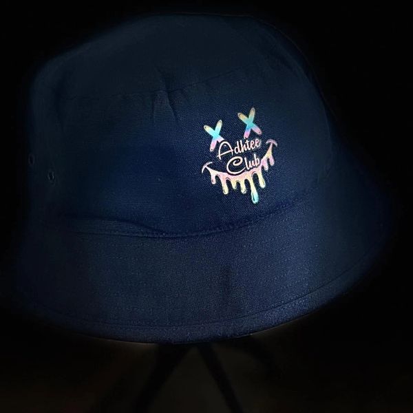 Dark bucket hat with colorful dripping smiley face and 'Adhtee Club' text.