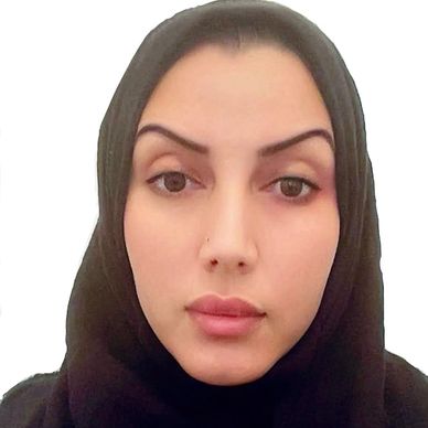 Close-up portrait of a woman wearing a black hijab against a white background.