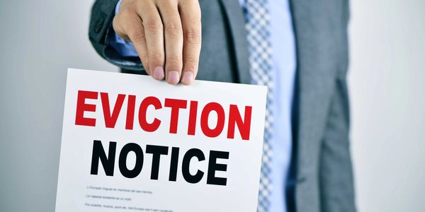 Man in suit holding out an eviction notice