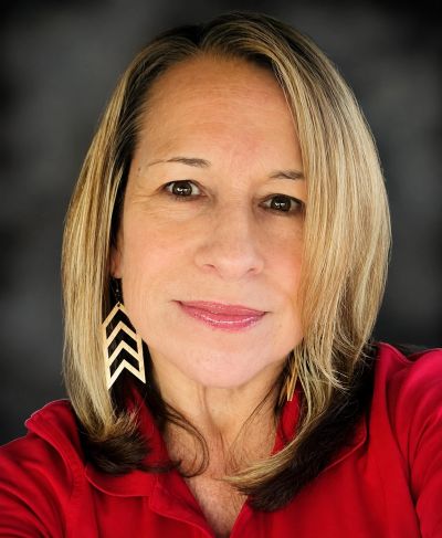 Close-up portrait of a smiling woman with blonde hair.