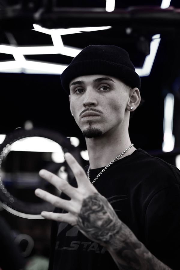 Young man in a beanie showing hand with tattoo in a modern setting.