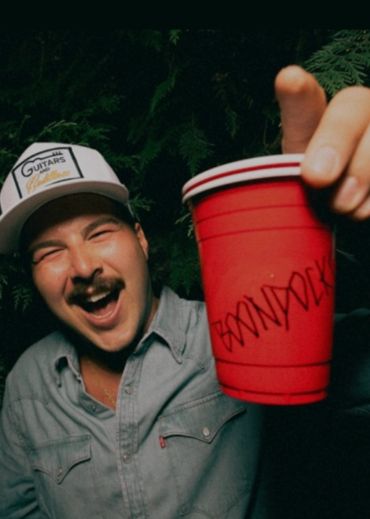 Happy man holding a red cup with writing.