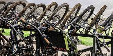 A van towing a trailer loaded with twenty mountain bikes