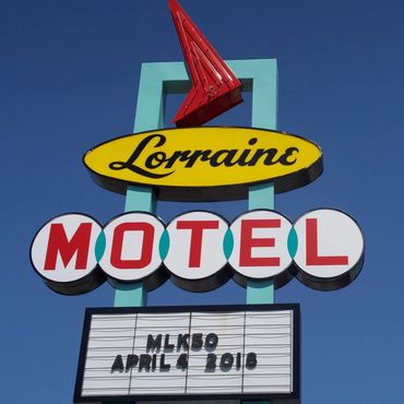 Vintage Lorraine Motel sign against a clear blue sky.