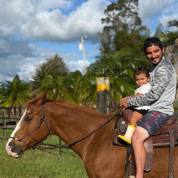 Adult and child riding a horse together.