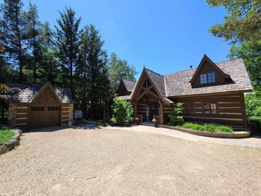 Restored Muskoka log home with professional wood restoration, media blasting, staining, and chinking completed.