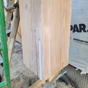 Close-up of a wooden structure with a green ladder.
