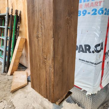 Wooden post with textured design at construction site.