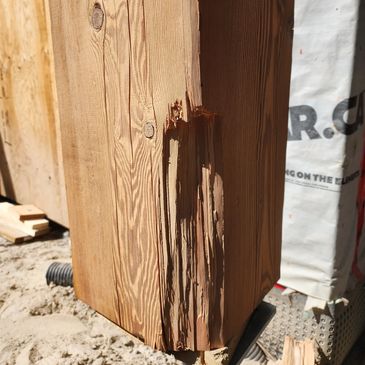 Damaged wooden post with splintered edges.
