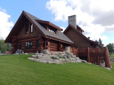 Restored Muskoka log home with professional media blasting and premium stain finish.