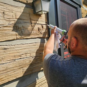 Log home restoration in Ontario. Caulking using Log Jam to fill cracks and checks in logs to prevent