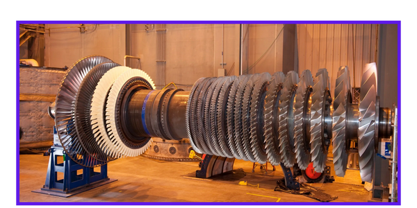 Large industrial turbine with multiple blades in a factory setting.