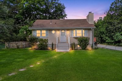 Small house with lit windows at dusk.