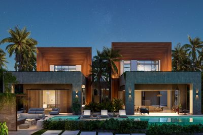 Modern twin villas with pools at dusk surrounded by palm trees.