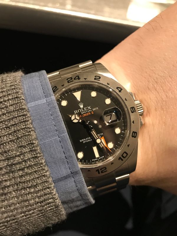 Rolex Explorer II watch on wrist showing time and date.