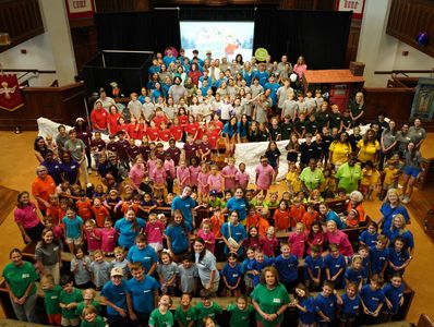 Grand groupe de personnes dans des t-shirts colorés rassemblées dans une salle.