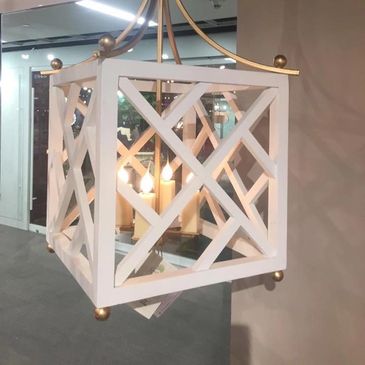 White lantern-style chandelier with candle-like light bulbs inside.
