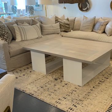 Cozy beige sectional sofa with multiple cushions and a modern wooden coffee table.