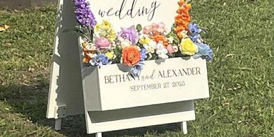 Wedding welcome sign for Bethany and Alexander with colorful flowers.