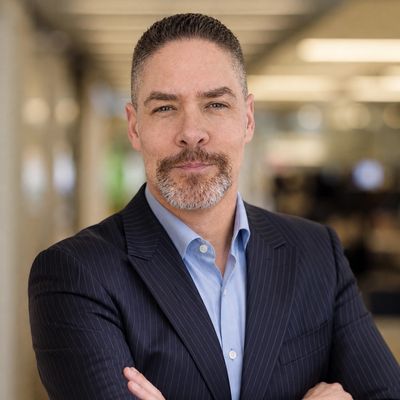 Confident man in a suit with arms crossed.