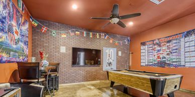Game room with pool table, TV, and colorful decorations.