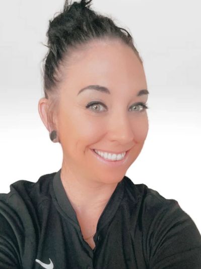 Smiling woman with dark hair in a black top against a white background.