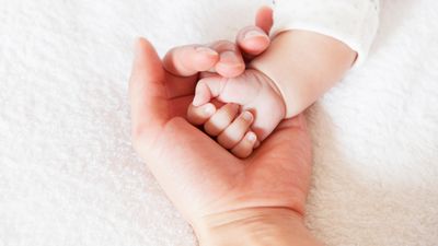 Professional baby care nurse holding newborn at home in Hyderabad