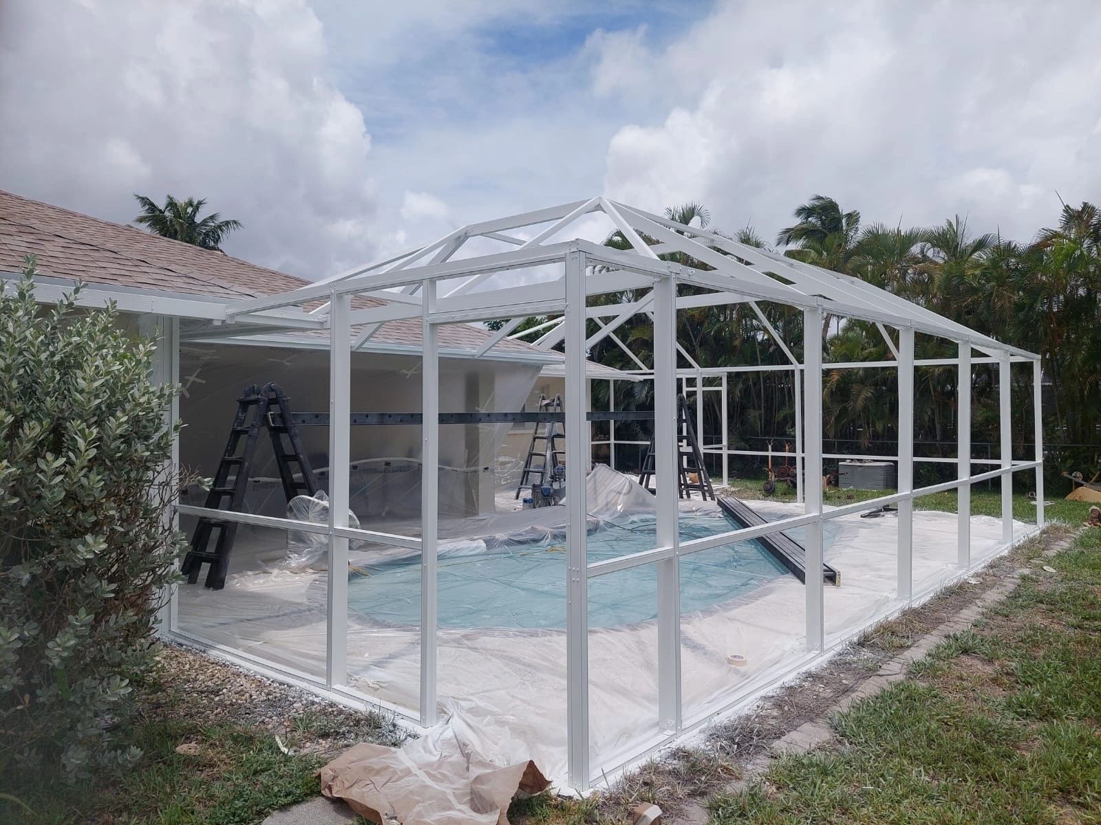 Pool cage painting Sarasota, Florida—beautiful white pool enclosure.