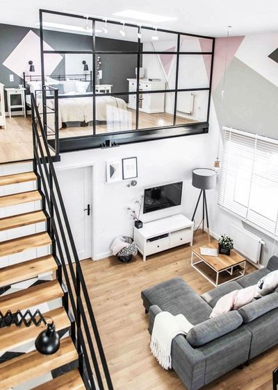 A photo of a loft apartment with furniture below and above.