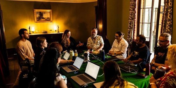 Group discussion around a table in a warmly lit room.