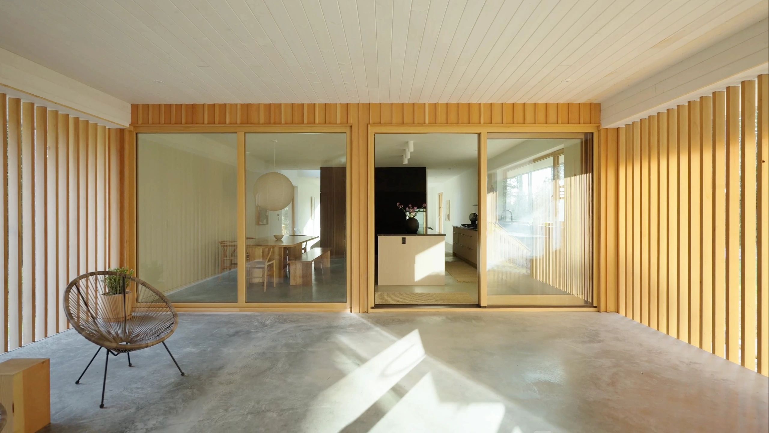 Modern patio with wood paneling and sliding glass doors.