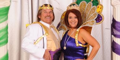A man and woman dressed as a king and queen with crowns and royal attire.
