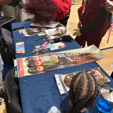 Hair extension products on a table at an event.