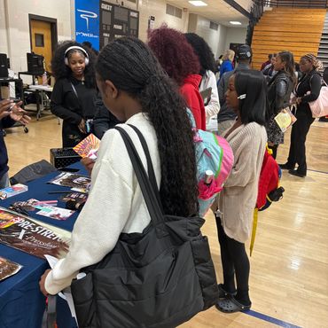 People at an indoor event looking at table displays.