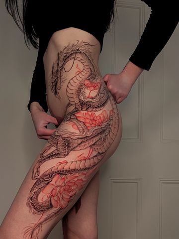 Dragon tattoo with peonies on hips in Asian style with black and red ink delicate  hand drawn design