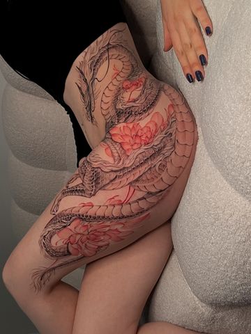 Dragon tattoo with peonies on hips in Asian style with black and red ink delicate  hand drawn design