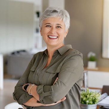 Smiling elderly woman with arms crossed