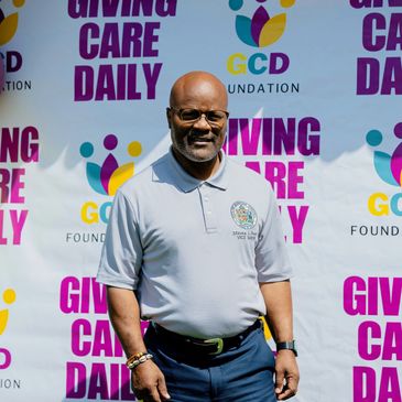 Man standing in front of a colorful foundation banner.