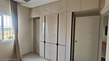 Modern bedroom with built-in wardrobes and a window.