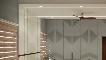 Modern bedroom with gray wardrobes and wooden accents.