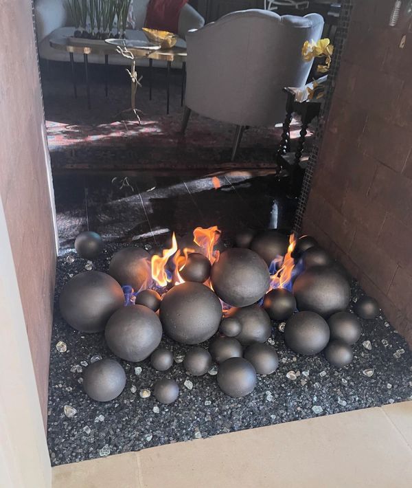 Modern fireplace with burning black spheres.