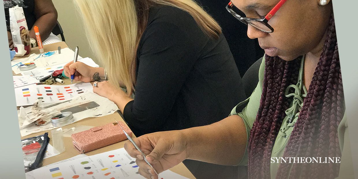 Two women focused on painting and drawing at a workspace.